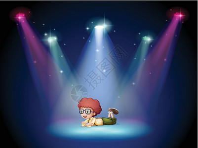 一个男孩躺在舞台的中间 带着聚光灯背景图片