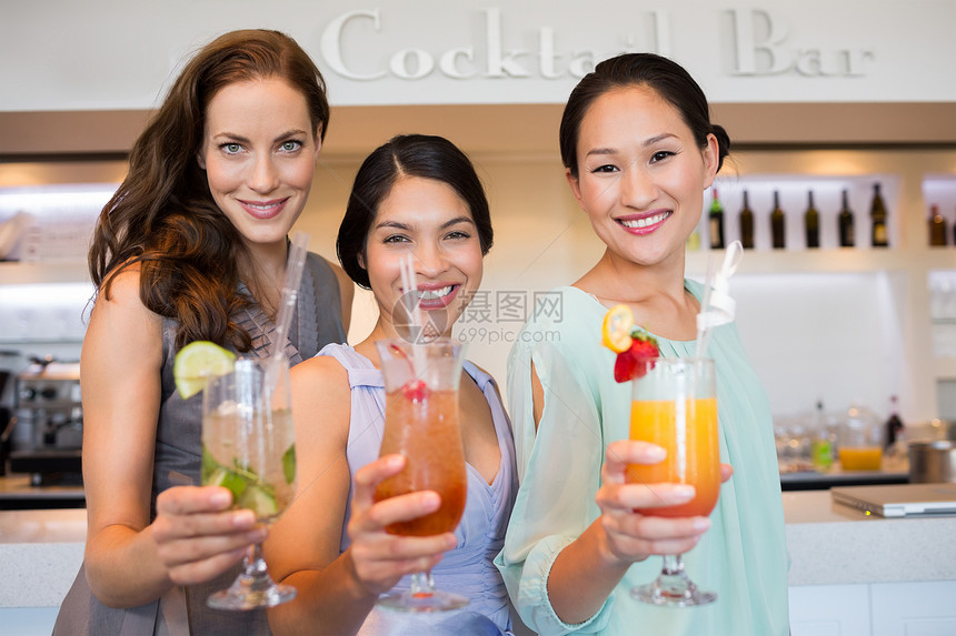 带着鸡尾酒杯的开心女人女性混血双手庆典享受微笑酒精闲暇玻璃成人图片