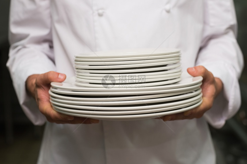 持有板块堆的厨师工作白人职业餐厅制服职员商业餐饮盘子厨房图片