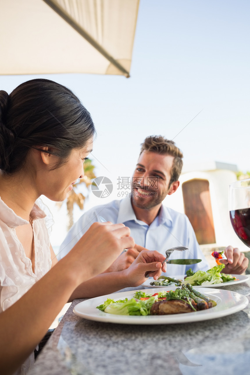 晚饭时快乐的一对情侣桌子男性闲暇咖啡店男人混血沙拉微笑阳台夫妻图片