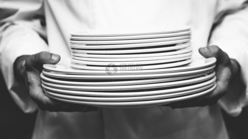 持有板块堆的厨师厨房大楼工作男性餐厅餐饮制服酒店盘子职业图片