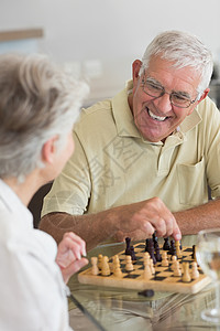 年长夫妇在下象棋和喝白酒头发公寓房子女士成人快乐竞赛游戏住所酒精背景图片