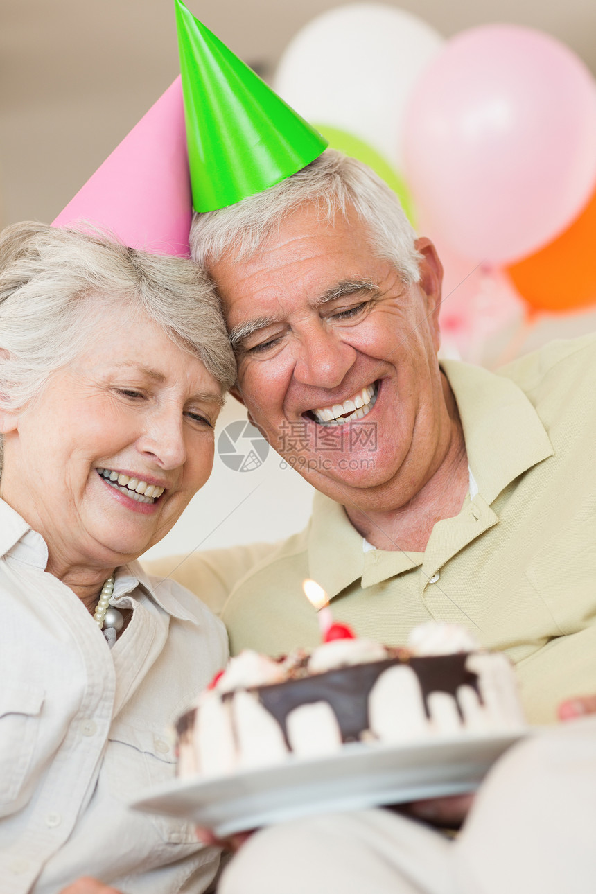 年长夫妇一起庆祝生日的晚年情侣沙发气球公寓微笑感情成人乐趣团结女性房子图片