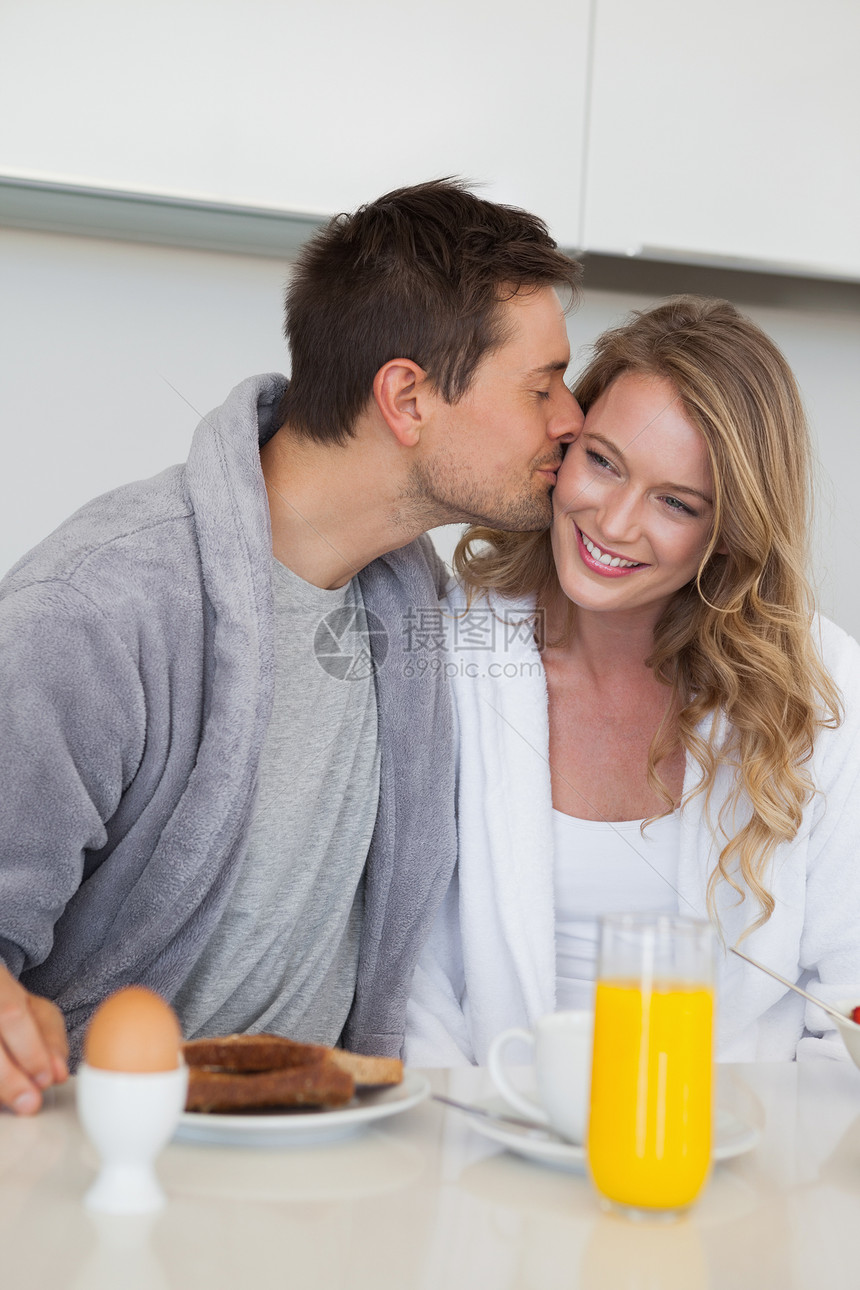 男人在早餐桌上亲吻快乐的女人亲热闲暇房子橙汁女性家庭生活桌子感情夫妻亲密感图片