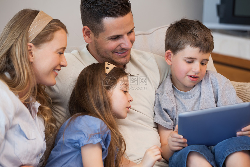 四口幸福家庭在客厅使用数码平板电脑图片