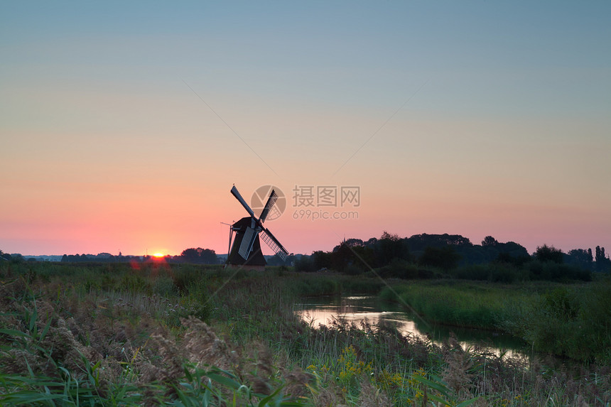 日出时荷兰风车草地运河紫色农田太阳风景农村文化天空蓝色图片
