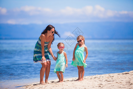 可爱的小女孩和年轻母亲在沙漠岛屿热带白沙滩上玩得开心幸福孩子婴儿父母异国海洋家庭成人乐趣女士异国情调高清图片素材