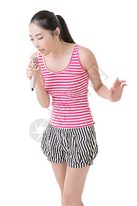 亚裔女孩用麦克风唱歌或说话娱乐展示讲话耳机女性派对乐趣歌手夜生活卡拉ok魅力高清图片素材
