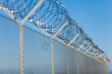 栅栏顶部的铁丝网对角线冒险障碍外壳隐私金属线圈蓝色镀锌监狱背景图片