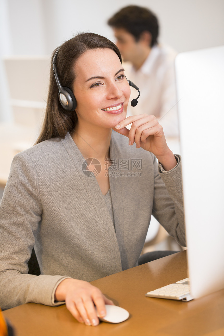 办公室的漂亮女商务人士在电话上 耳机秘书推销女孩对话操作员顾问网络顾客中心女士图片