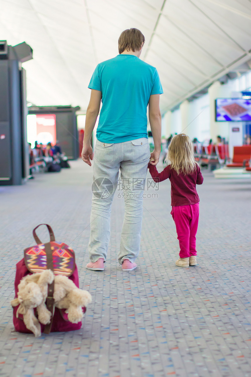 在机场等待飞行的小女孩和年幼父亲的近视中图片