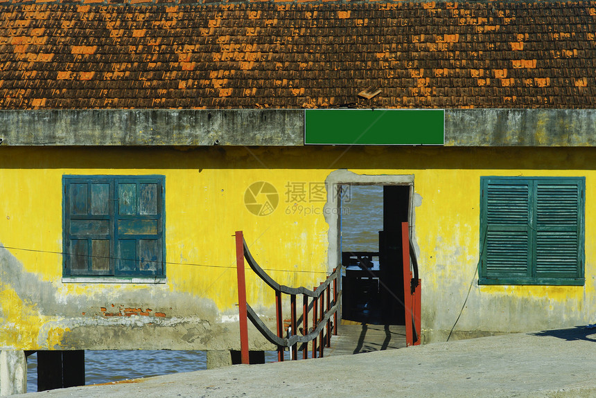 越南水面上的旧黄屋蓝色音调石膏文化凸轮石头快门房子木头框架图片