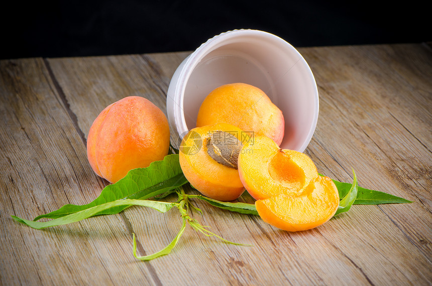 木桌上的杏子宏观甜点维生素水果白色桌子木板种子植物橙子图片
