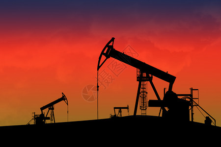 日落时的油泵工业汽油管道天空商业气体环境钻孔资源油井背景图片