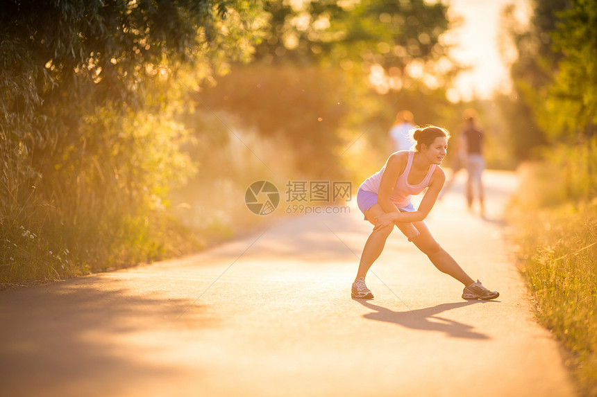 年轻女子在阳光明媚的夏日夜晚户外奔跑公园运动越野慢跑者草地运动员活力女孩娱乐城市图片