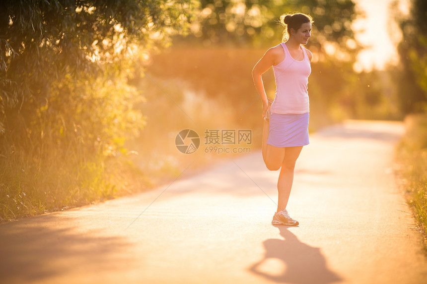 年轻女子在阳光明媚的夏日夜晚户外奔跑草地慢跑者背景城市赛跑者公园运动装娱乐女孩活力图片