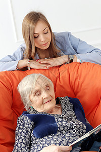 带孙女的老年妇女女儿发型家庭奶奶皱纹微笑椅子夫妻女性祖母书高清图片素材