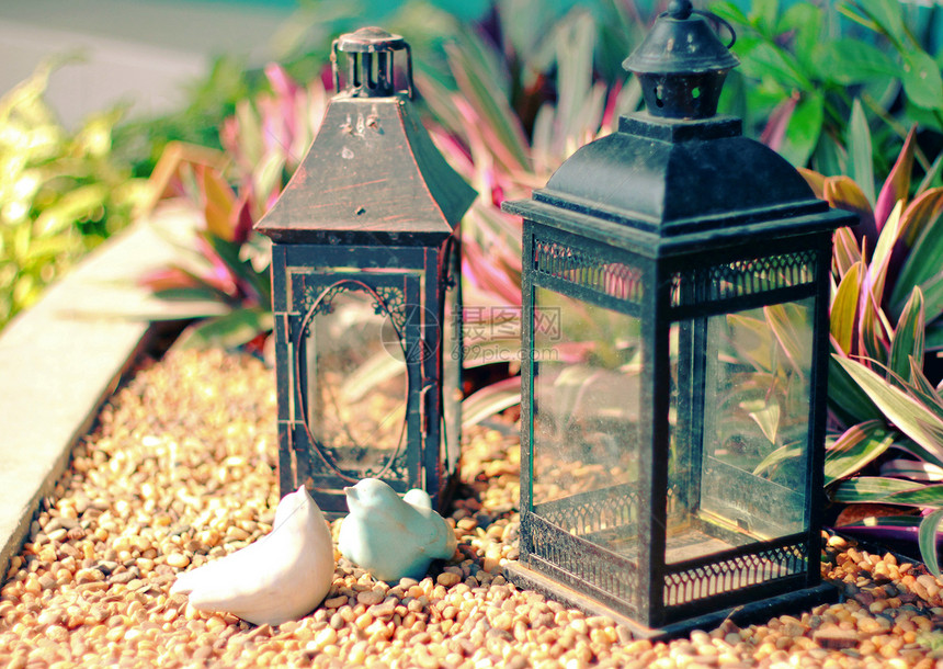 装饰花园的陶瓷鸟和古老灯具图片