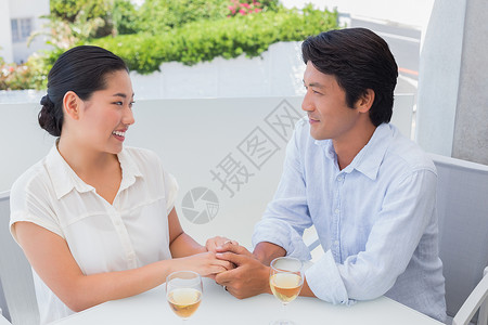 幸福的情侣握手 喝白酒微笑阳台酒精空闲住所女士桌子快乐闲暇夫妻背景图片