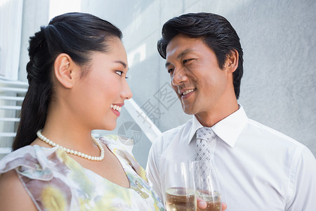 快乐的一对情侣穿了衣服 约会有香槟闲暇泡酒裙子长笛玻璃住所领带酒精女性男性背景图片