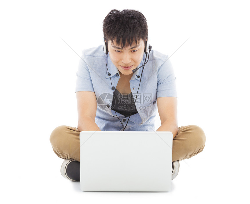 坐在地板上使用笔记本电脑的年轻人图片