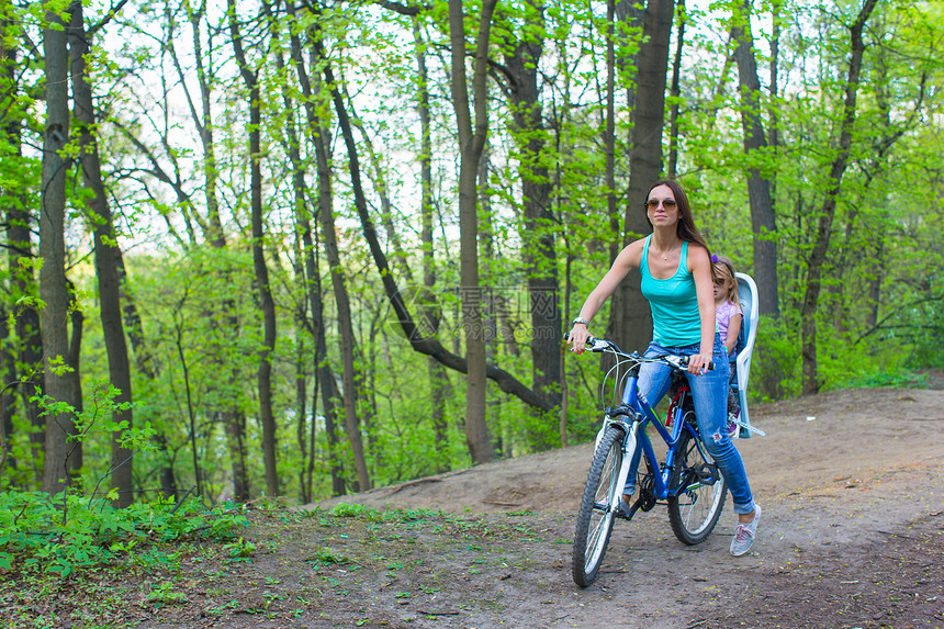 母亲和女儿骑自行车在公园里骑自行车女士女孩骑术闲暇家庭运动活动童年乐趣喜悦图片