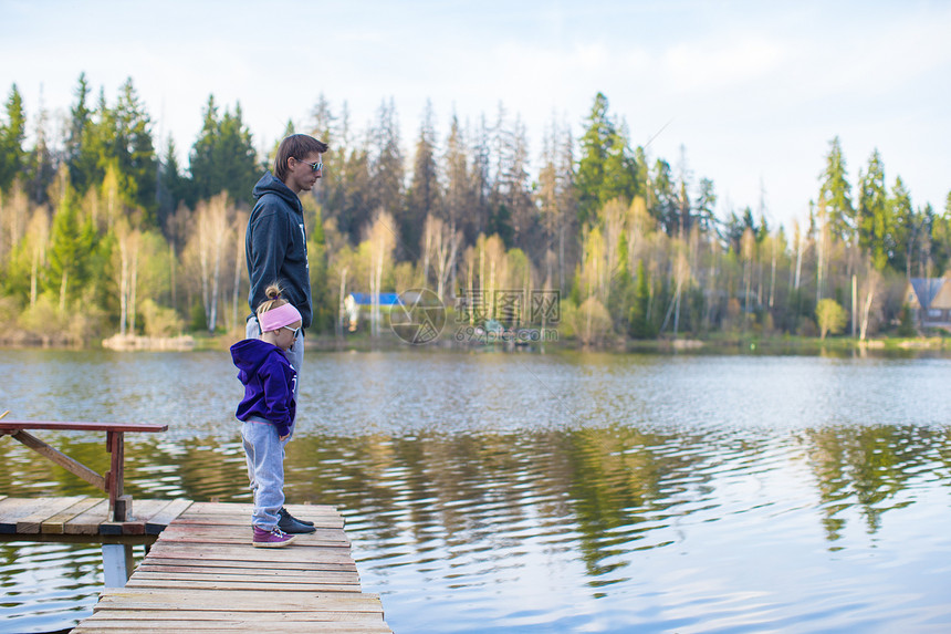 小女孩和她父亲在湖边走来走去图片
