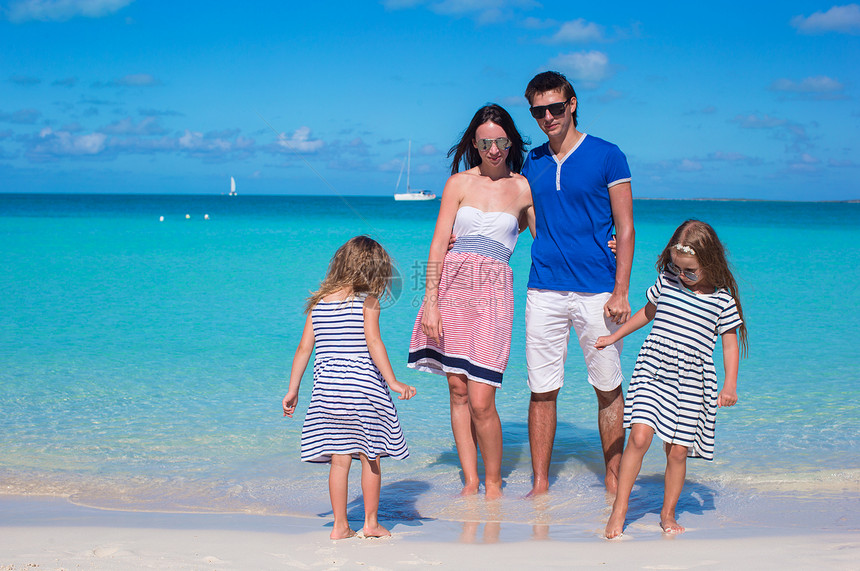 四口幸福的一家四口在沙滩度假成人爸爸父母女儿男人女孩享受家庭海滨旅行图片