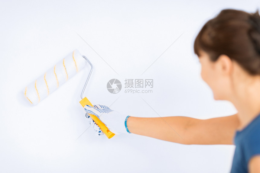 妇女用滚滚和油漆涂墙彩色画家乐器工艺家务女孩滚筒墙壁装潢白色染料图片