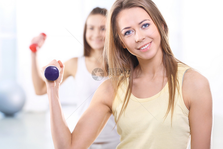 在健身房培训有重体重的两名年轻妇女爱好活力弯曲体操皮肤幸福喜悦女孩哑铃朋友图片