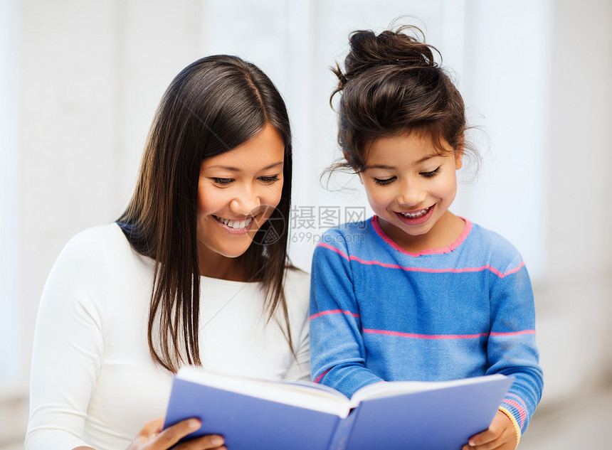母亲和女儿的书本家庭小学生学校作业童年母性微笑知识学者孩子们图片