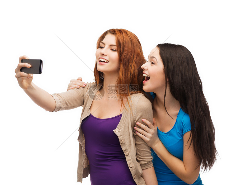 两个带着智能手机的笑笑青少年朋友们拍照闺蜜学生乐趣幸福互联网微笑友谊电话图片