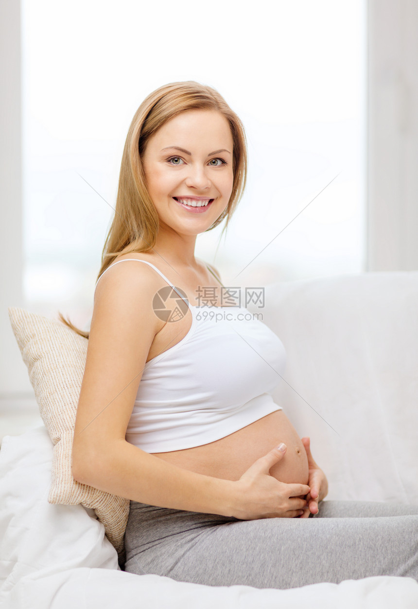快乐的孕妇抚摸她的肚子怀孕女士母性家庭婴儿幸福腹部女孩父母沙发图片