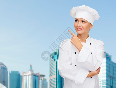 笑着的女厨师指着男儿工作女性职业广告帽子手指管理人员食物女士面包师背景图片