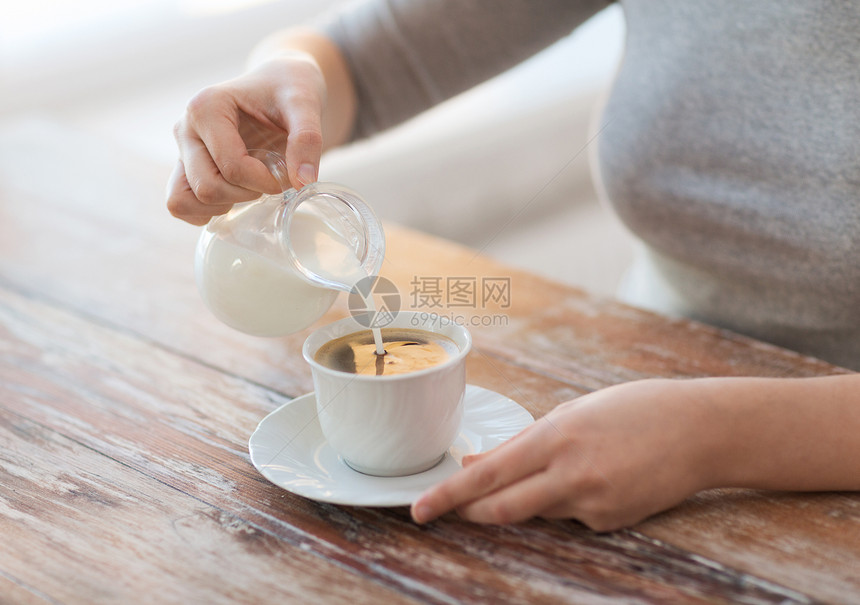 将乳汁加于咖啡中的女性盘子桌子饮料拿铁活力享受杯子女士泡沫香气图片