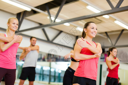 一群微笑的人 在健身房里伸展身体运动男人损失哑铃团队护理训练减肥班级背景图片