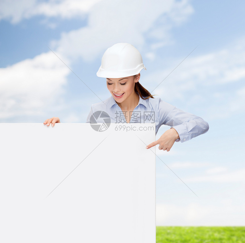 戴头盔的女商务人士用手指对着板女士天空成人承包商建设者工作微笑人士木板广告图片