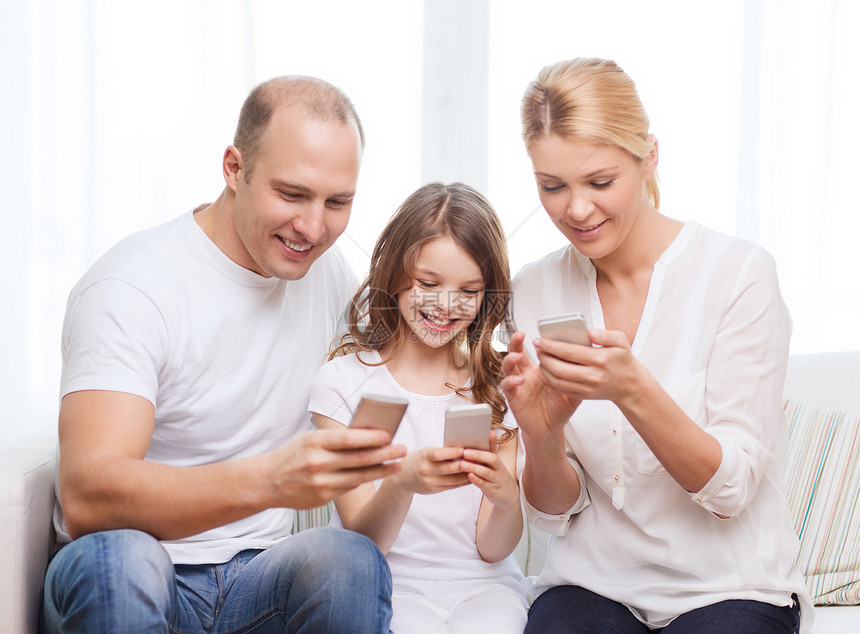 父母和家里有智能手机的小女孩的父母技术互联网母亲男人女儿女士妈妈青少年童年青春期图片