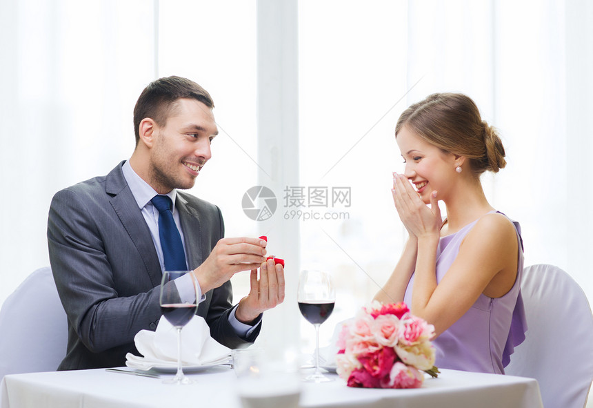 男人向在餐厅的女朋友求婚的男人展示未婚夫花朵庆典未婚妻珠宝男朋友家庭女士生日图片