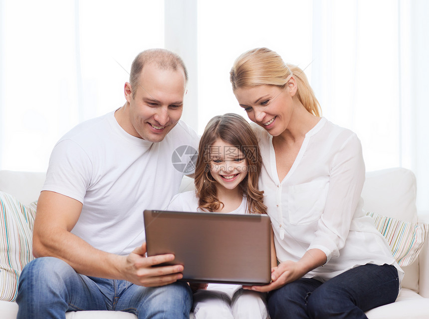 家里有笔记本电脑的父母和小女孩母亲幸福成人乐趣微笑青春期上网女士爸爸技术图片