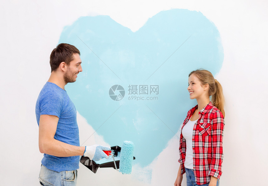 一对在墙上画着大心的情侣幸福家庭刷子画笔女性夫妻装修女士手套房子图片