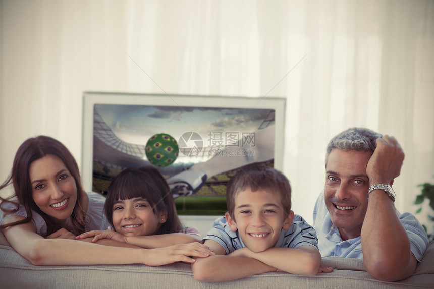 家庭在摄影机前微笑 电视上展示世界杯享受孩子欢呼长椅女士客厅男性足球杯子儿子图片
