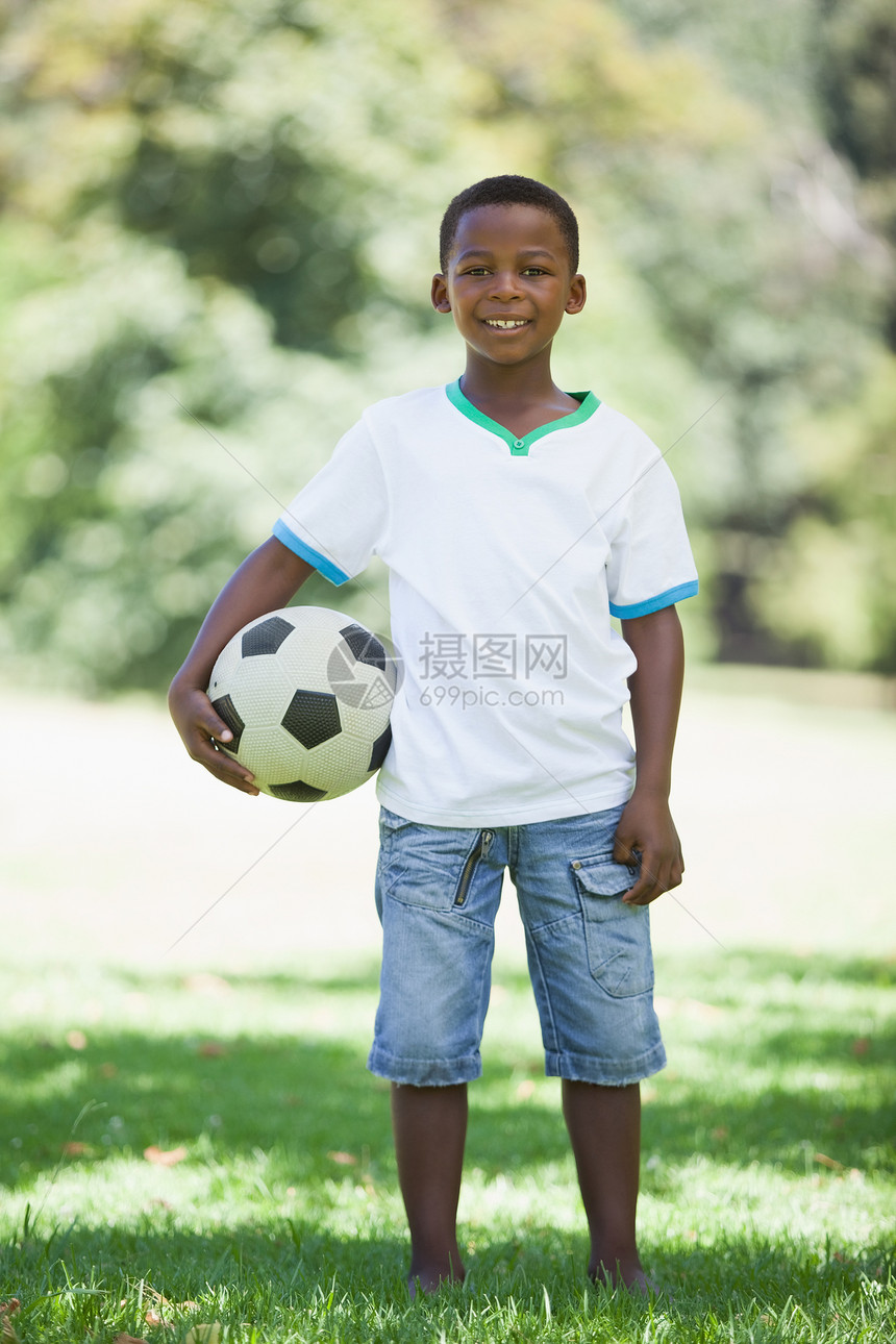 小男孩在公园里拿着橄榄球 微笑着看镜头运动黑色男生农村足球快乐晴天活动阳光男性图片