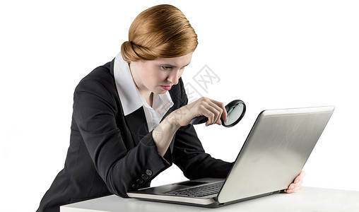使用笔记本电脑的红头女商务人士放大镜桌子女士人士女性公司红发技术职业好奇心专业的高清图片素材