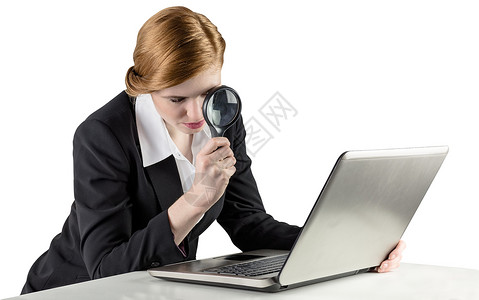 使用笔记本电脑的红头女商务人士放大镜好奇心人士搜索女性专注女士职业商务调查红发高清图片素材