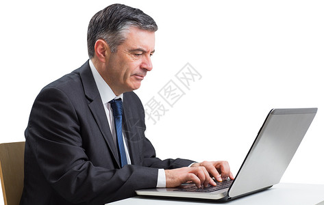 使用笔记本电脑的成熟商务人士桌子人士商务商业专注头发职业套装男性公司公司的高清图片素材