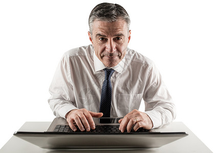 使用笔记本电脑的成熟商务人士职业套装桌子技术商务头发人士公司男性专注无线的高清图片素材