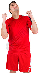 兴奋的年轻足球运动员欢呼胜利运动服微笑快乐活动运动男人齿轮红色欣快感背景图片