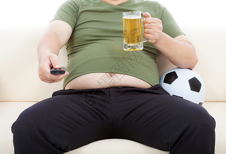 喝啤酒坐在沙发上看电视的胖子高清图片