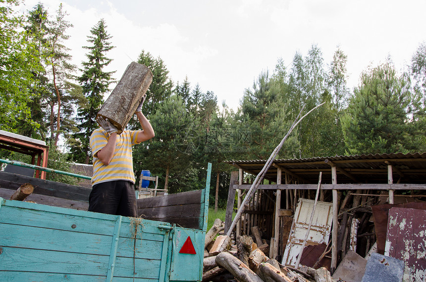 工人从拖车中卸下木柴图片